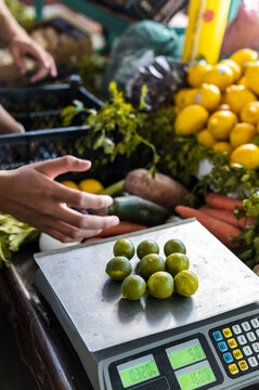 Bunch of limes in weighing scale on vegetable store
