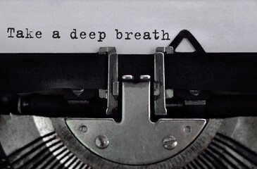 Text Take a deep breath typed on retro typewriter	
