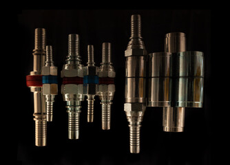 Set of fittings, quick couplings for hose isolated, bolts on a black background with reflection.