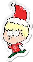 distressed sticker cartoon of a curious boy running wearing santa hat
