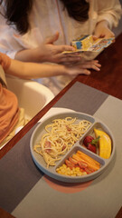 kids meal set, spaghetti carbonara with fruits and vegetables, carrot tomato and cord, on food grade plate for kid, children or toddler, top view