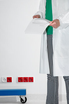 Woman in lab coat hold papers