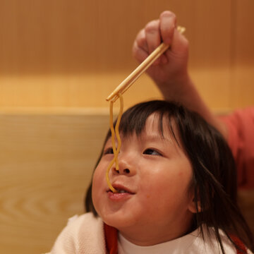 Cute little girl eating noodle