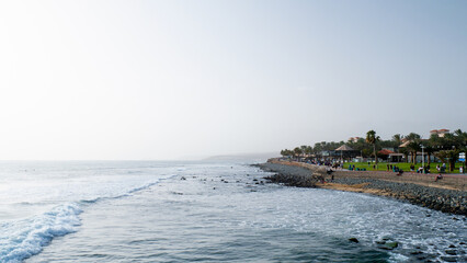 View of a coast full of people with a rocky beach 