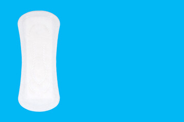 Feminine hygiene menstrual pad for the menstrual cycle on a blue background. Feminine hygiene product in the form of a sanitary napkin. Clean menstrual pad. Free space for text