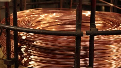 Copper wire, industrial facility, cable manufacturing. Industrial facility produces copper wire, which is then coiled in circular shape for cable manufacturing.
