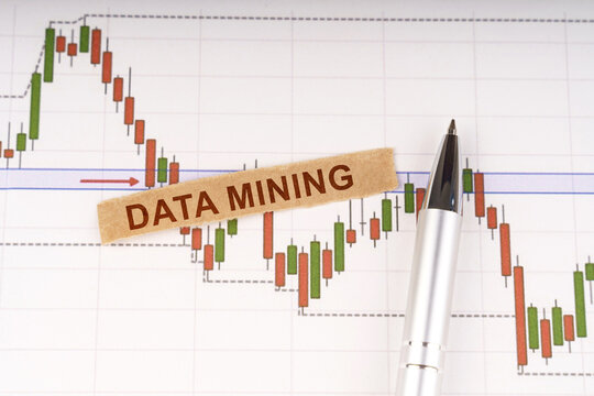 On the chart of business quotes lies a pen and torn paper with the inscription - DATA MINING