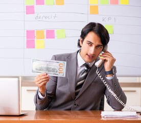 Young handsome employee working in the office