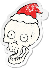distressed sticker cartoon of a skull wearing santa hat