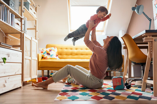 Happy mother playing with her son at home