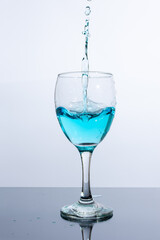 Liquid of beautiful blue color is poured into a glass