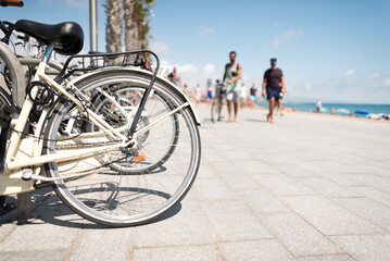 Parked bicycles near the beach with blurred people