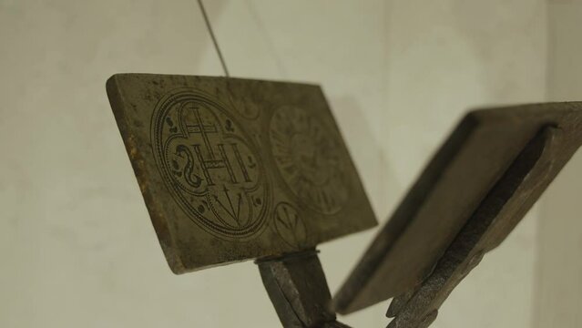 Metal vintage tongs with abbreviation IHS for making communion wafer, close-up. Ancient hand tool for making unleavened thin bread for church in museum, nobody.
