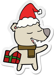 sticker cartoon of a bear with present wearing santa hat