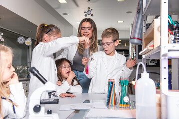 Diverse schoolchildren with teacher work together on science project