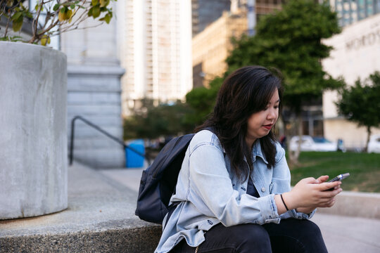 Normal person downtown using cell phone.
