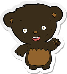 sticker of a cartoon black bearcub waving
