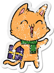 distressed sticker of a happy cartoon cat with christmas gift