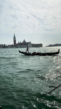 Gondolier entering the port of Venice, Italy. A trip to a romantic city. Tourists in a European city.