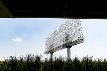 Large empty billboard frame in a grassy field in Bangkok, Thailand