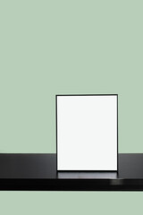 Black Empty Frame mockup on black table with Green background