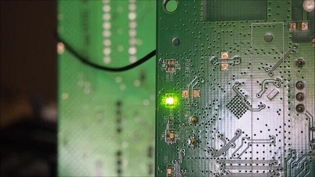 Blinking green led indicator on electronic circuit board. Online device or data transmission concept