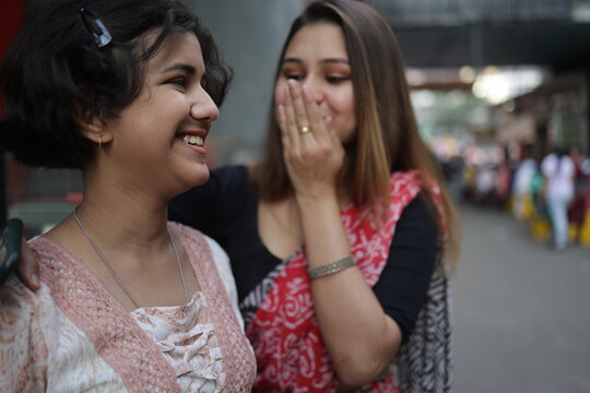 Sisters making fun and sharing happy moments at outdoors in urban city