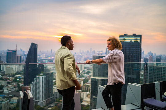 Two men having conversation at rooftop restaurant