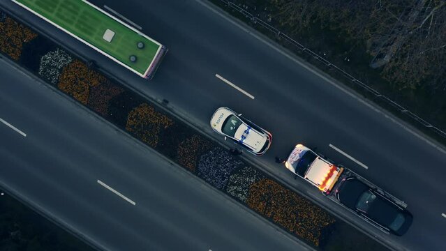 Aerial spinning shot night Car accident in european city. Police flashlights, traffic police draws up a place of an accident, a damaged car is evacuated by a tow truck. Car crashed into a city bus