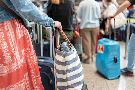 unrecognizable woman waiting to check bags at airport