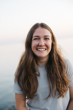 Smiling, happy young woman near the ocean water.