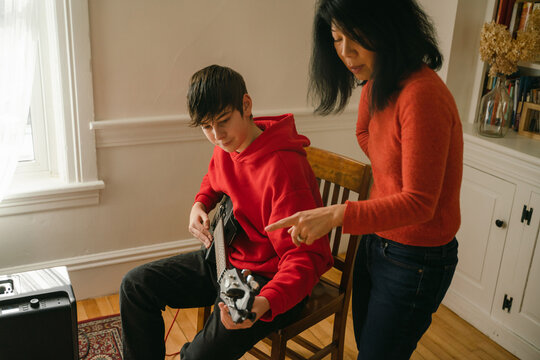 teen getting guitar lesson 