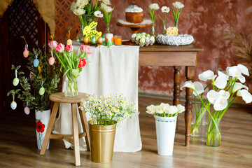 Easter festive table. Fresh flowers and a cupcake, eggs and lots of themed decor