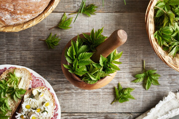 Fresh goutweed or ground elder leaves in a wooden mortar, top view