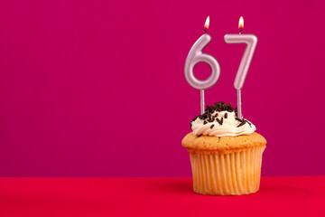 Candle number 67 - Cake birthday in rhodamine red background