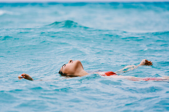 Woman swimming on back in sea