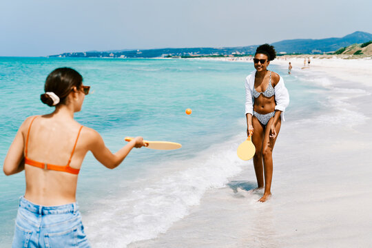 Young friends playing ping pong on beach