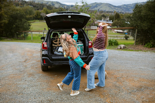 Excited female friends travel by car