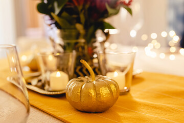 Thanksgiving dinner table setting. Golden pumpkin close-up,