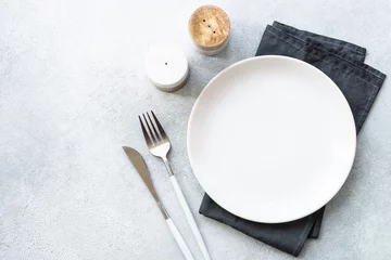 Fotobehang White plate and cutlery on stone table. Table setting, flat lay image. © nadianb