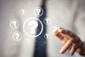 Businessman on blurred background holding hand drawn question marks