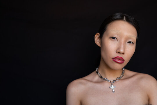 Self-confident young Asian woman with creative makeup and freckles