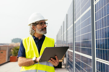 Male engineer with digital tablet near solar panels