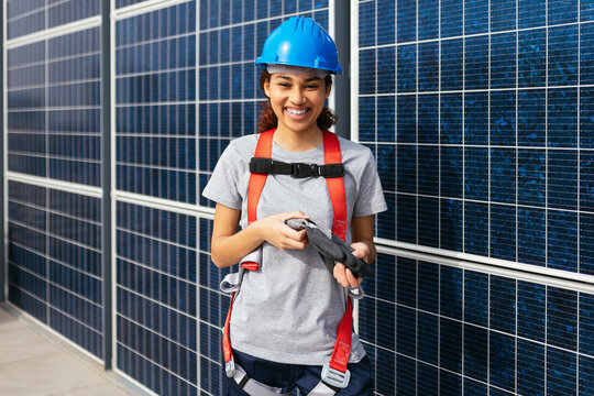 Smiling engineer female in front of solar power station
