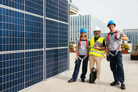 Engineer with builders standing along solar power station