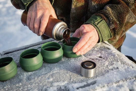 Hands pouring coffee from a thermos