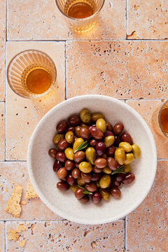 Overhead Shot of Bowl of Mixed Olives with Glasses of Grappa