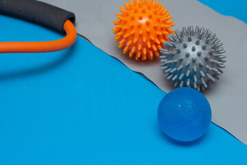 three small pilates balls on a gray elastic band