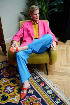 Fashion portrait of a beautiful adult woman in a bright suit