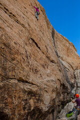 climber on a cliff with belay